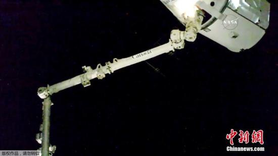 资料图片：“龙”飞船飞临国际空间站，成功被国际空间站机械臂捕获。