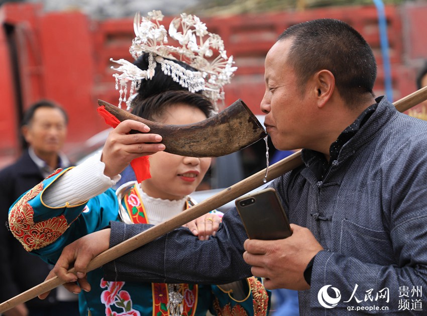 苗族村民为回娘家的"姑爹"敬上拦门酒(陆德华 摄)